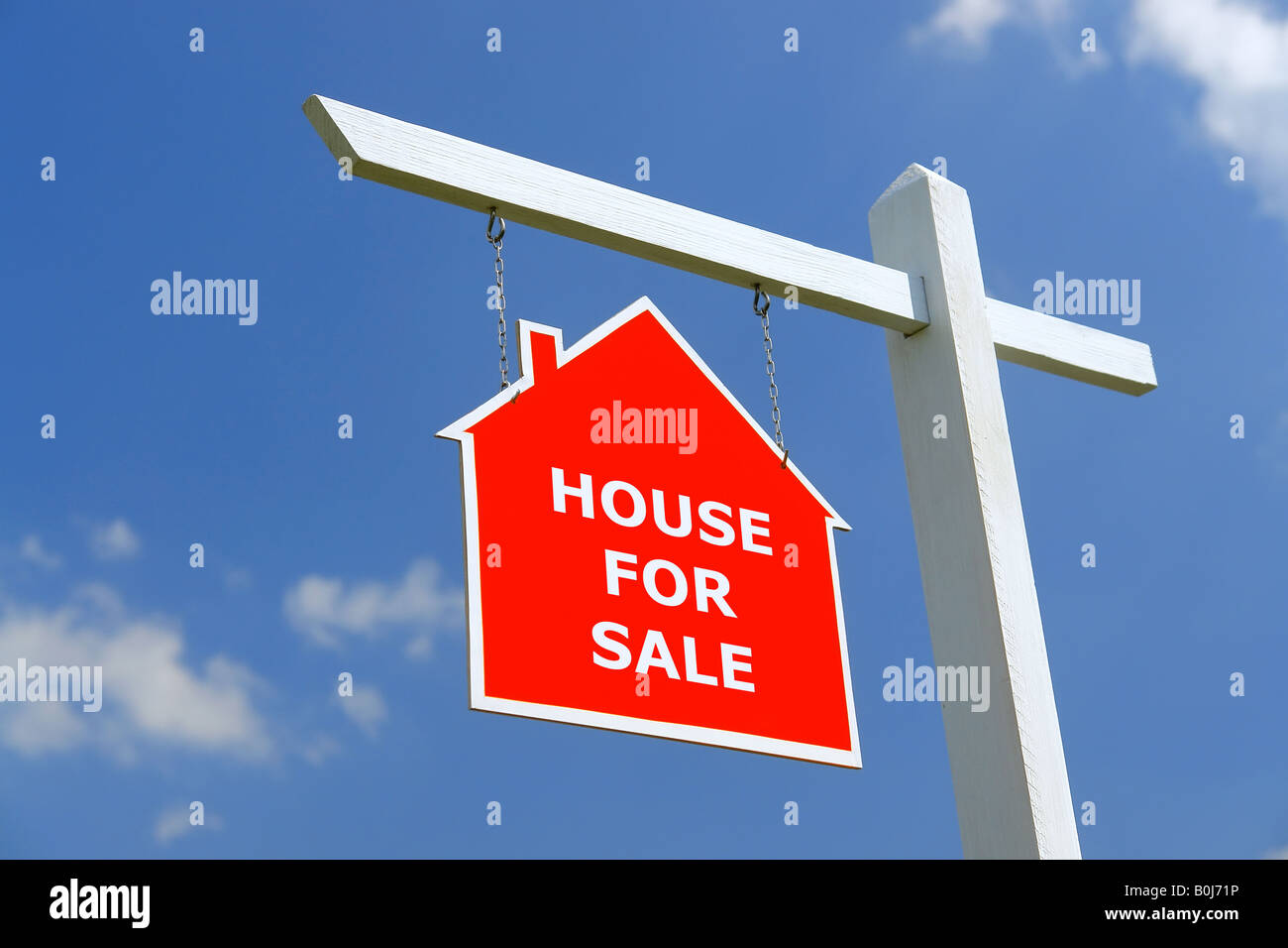 White wooden post with red House for Sale notice board over blue sky Stock Photo