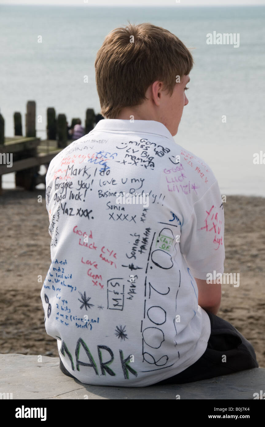 Young boy secondary school pupil wearing white shirt signed by all his friends at the end of the school summer term, Wales UK Stock Photo
