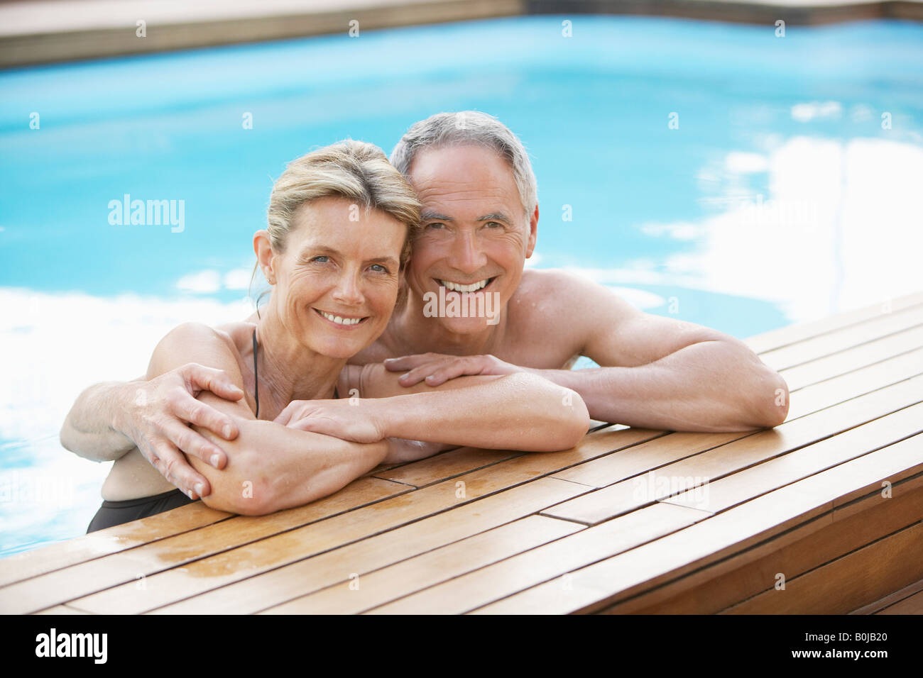 Senior Couple Relaxing in Swimming Pool Stock Photo - Alamy