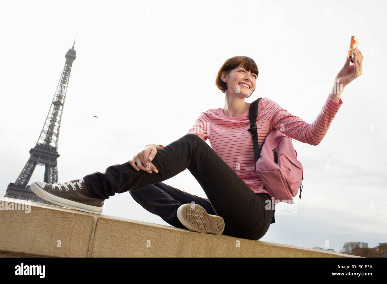 Tourist Using Camera Phone and Eiffel Tower Stock Photo