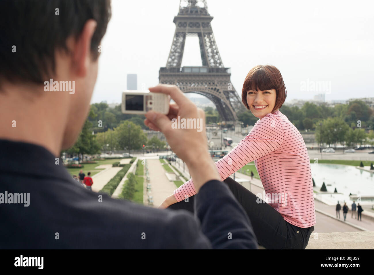 Couple Using Camera Phone and Eiffel Tower Stock Photo