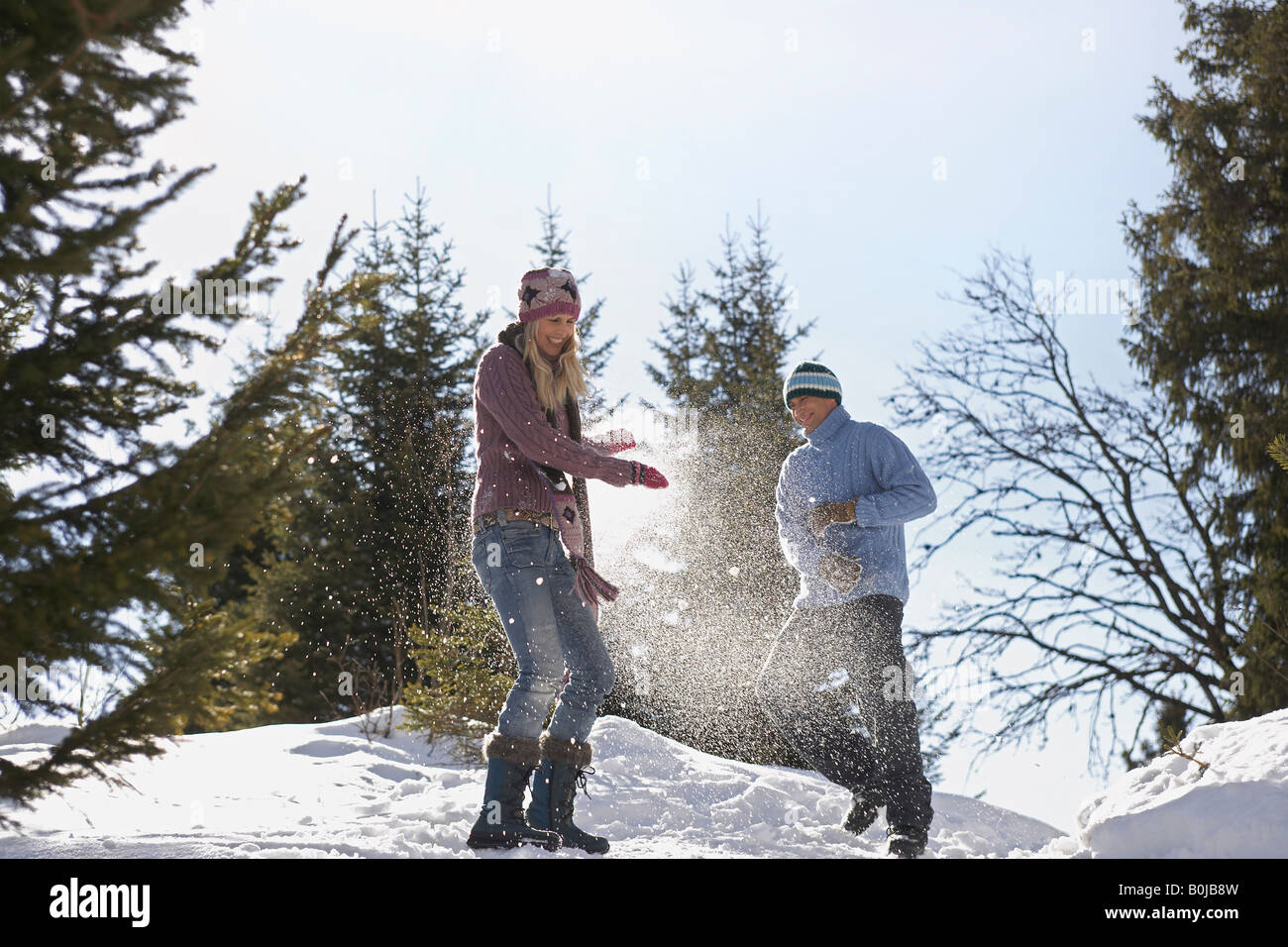 Couple playing in snow on hill Stock Photo - Alamy