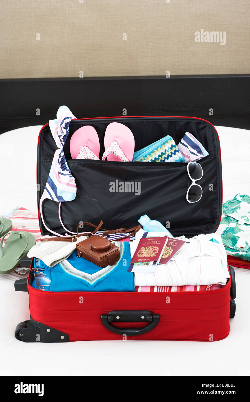 Open suitcase on bed, elevated view Stock Photo