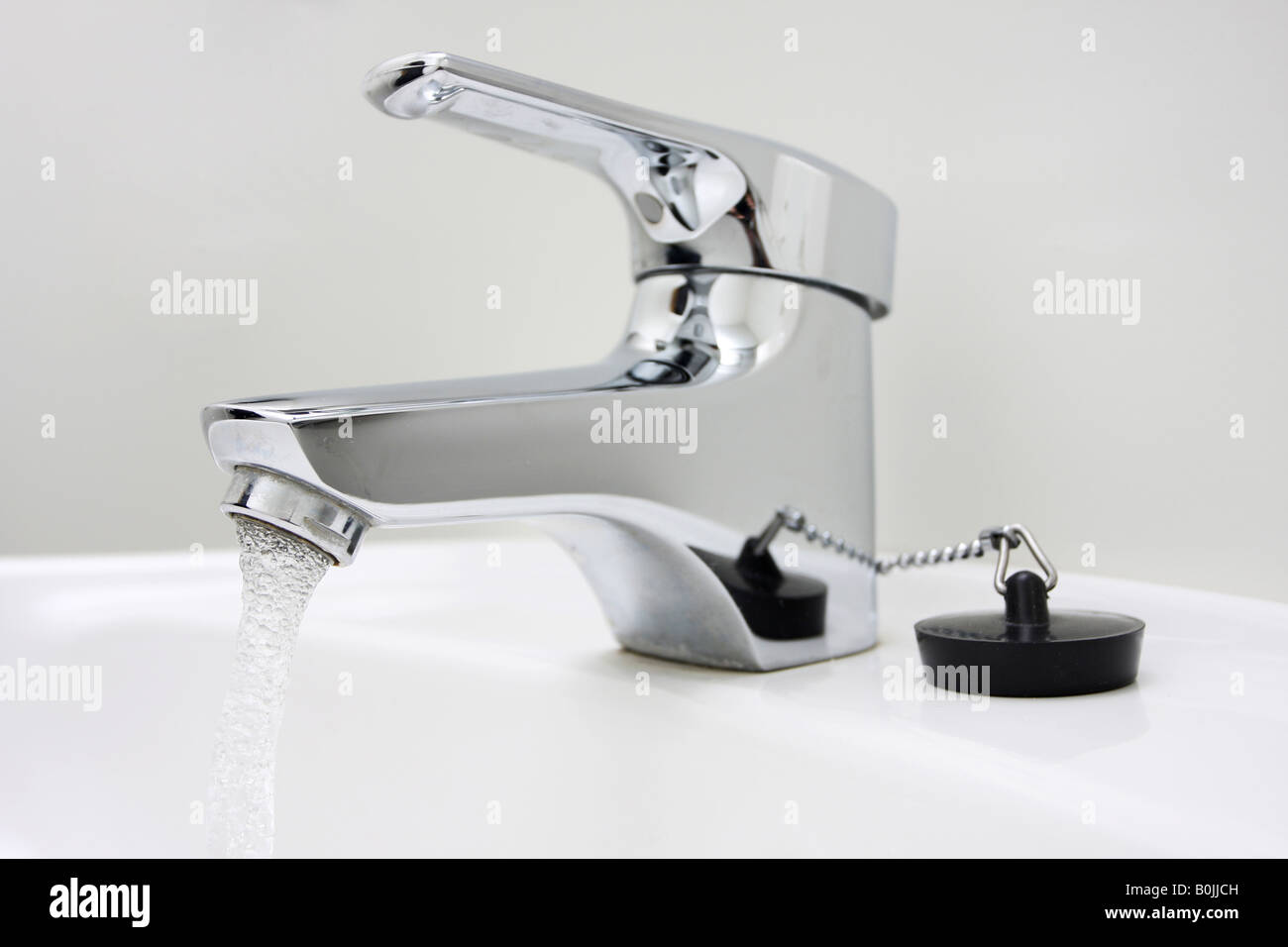 chrome faucet on a sink running water Stock Photo Alamy