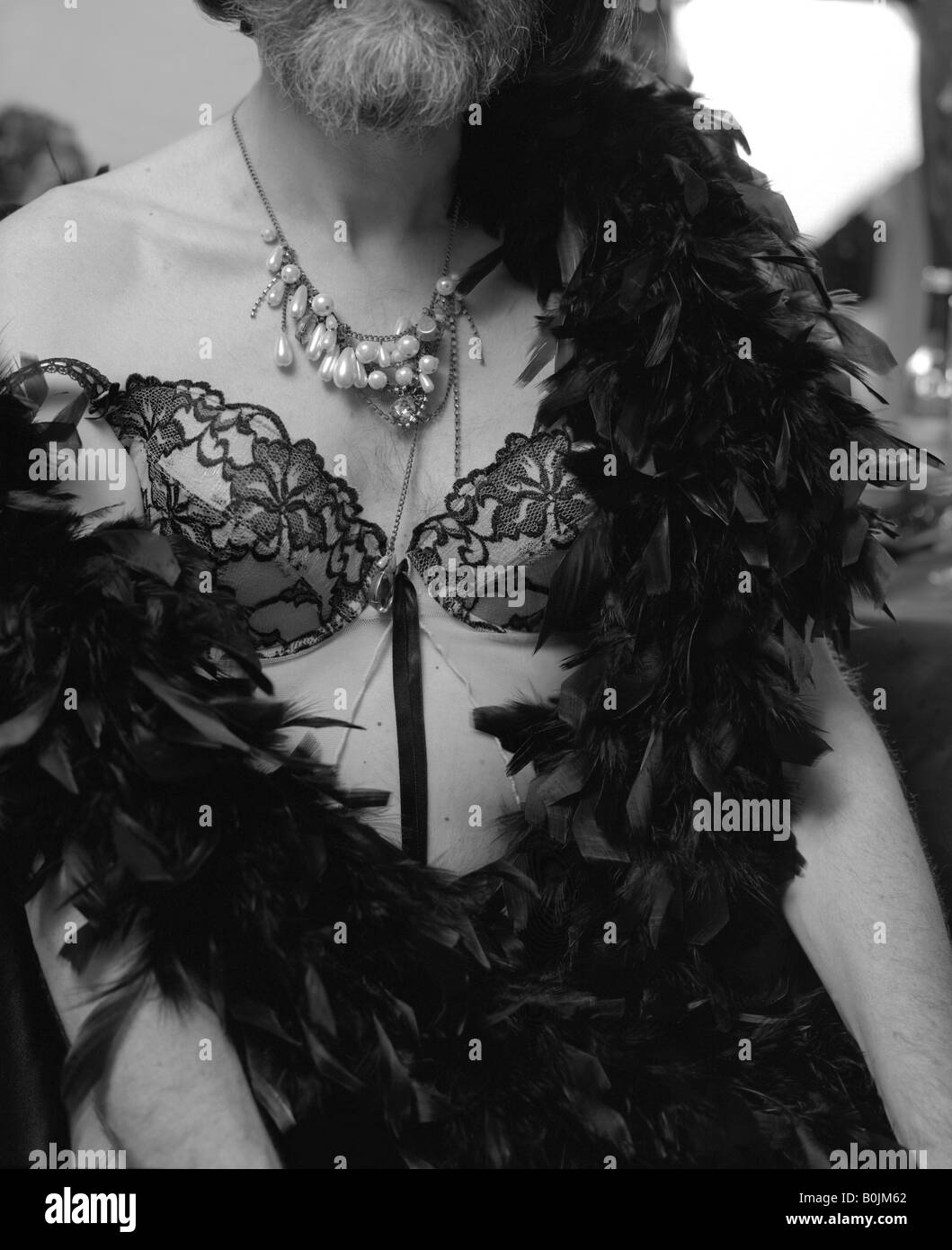 Cross Dressed Man Wearing Lingerie Pearl Necklace And A Feather
