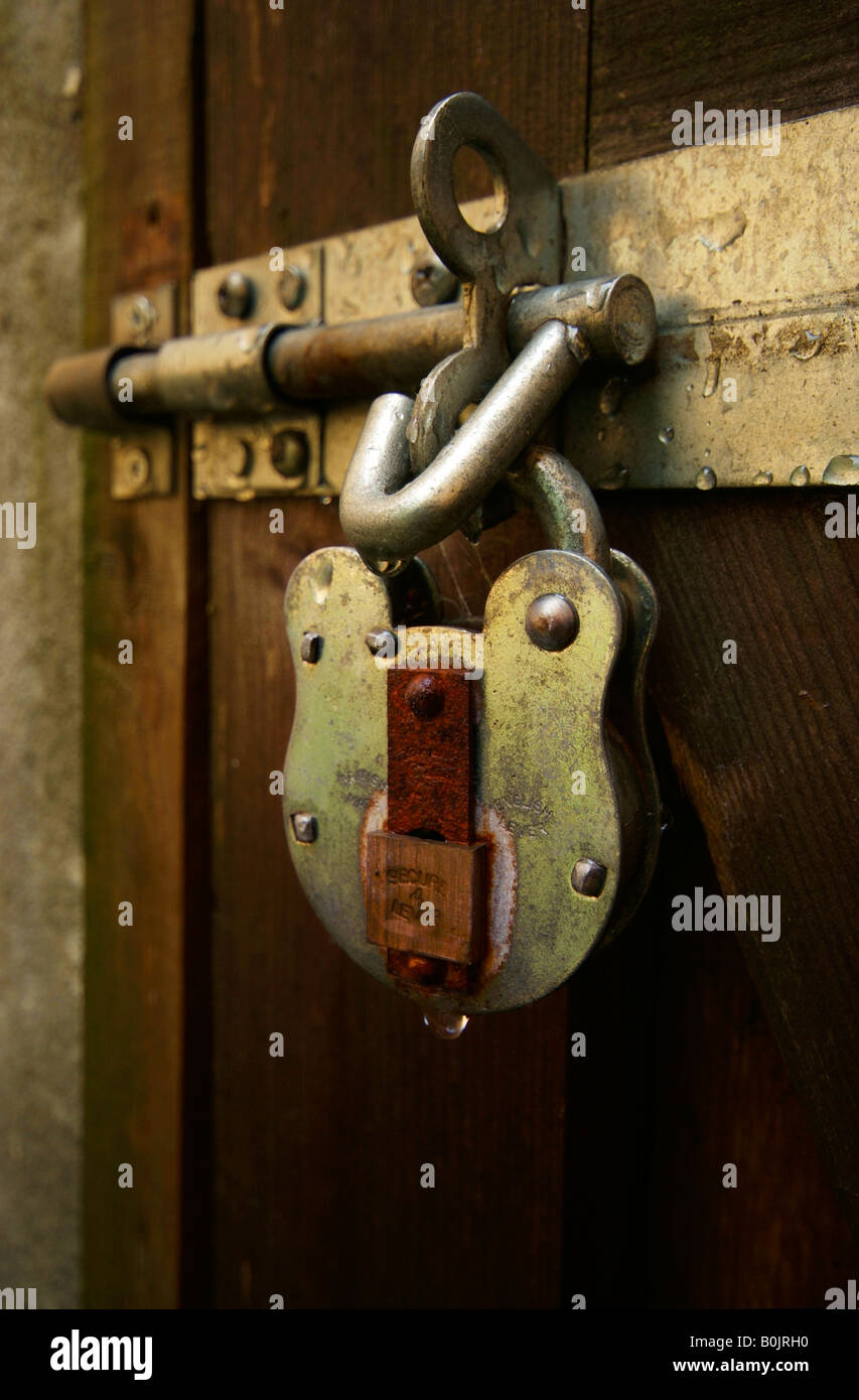 A lock and padlock attached to a gate for security and protection Stock Photo