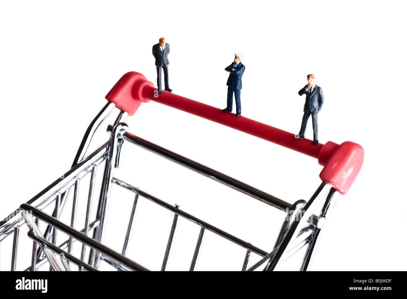 Businessman figurines standing on a shopping cart Stock Photo