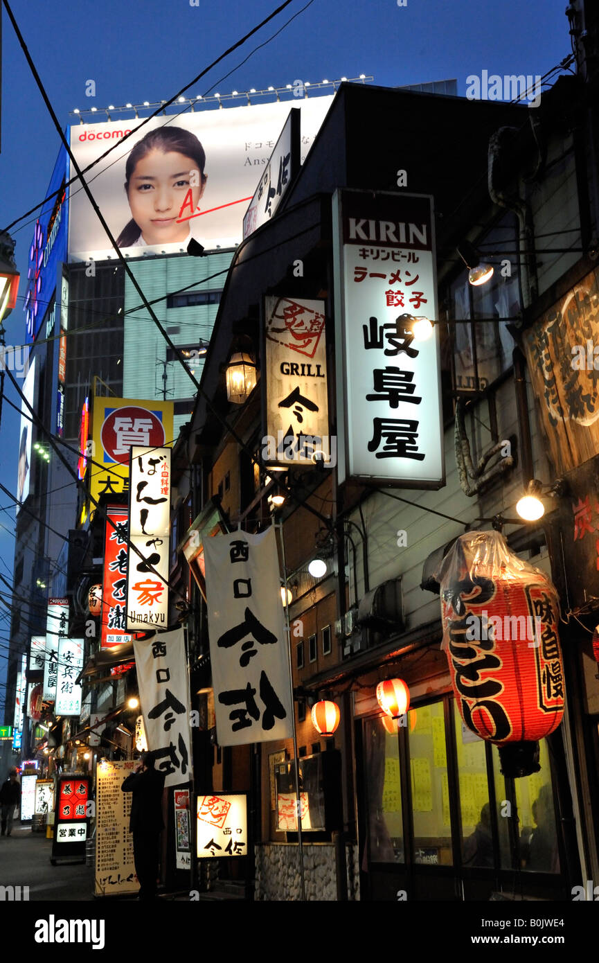 Many illuminated signs in alley full of bars and restaurants at Shomben Yokocho in Shinjuku central Tokyo Japan Stock Photo