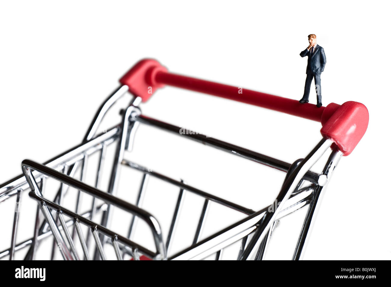 Businessman figurines standing on a shopping cart Stock Photo
