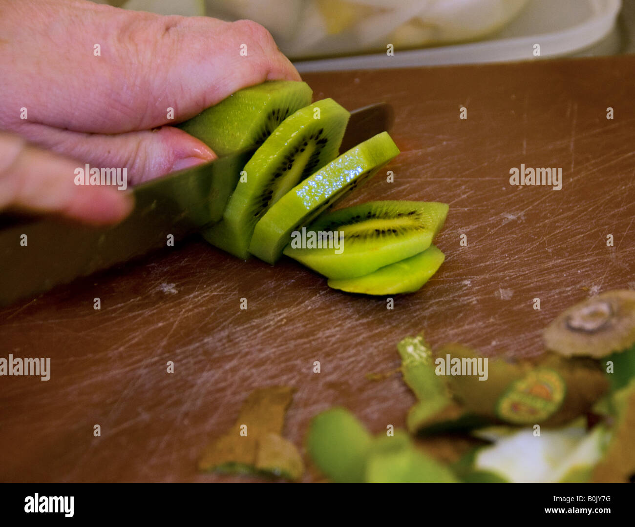 Food preparation - A Kiwifruit being sliced. Stock Photo