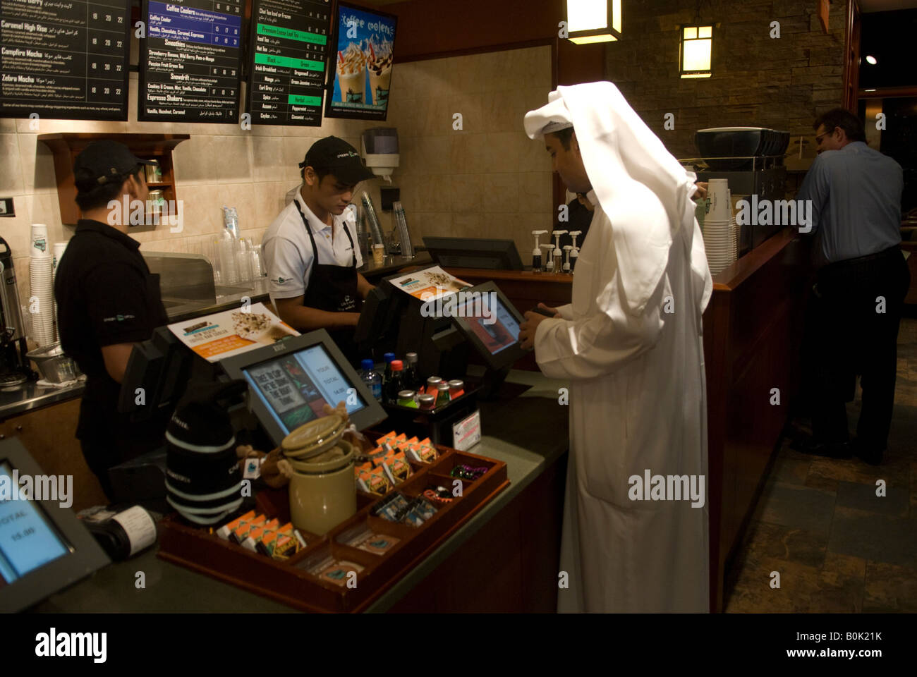 A kuwaiti orders at CARIBOU coffee in the Dubai International Financial Center. Un koweitien commande un cafe. Stock Photo