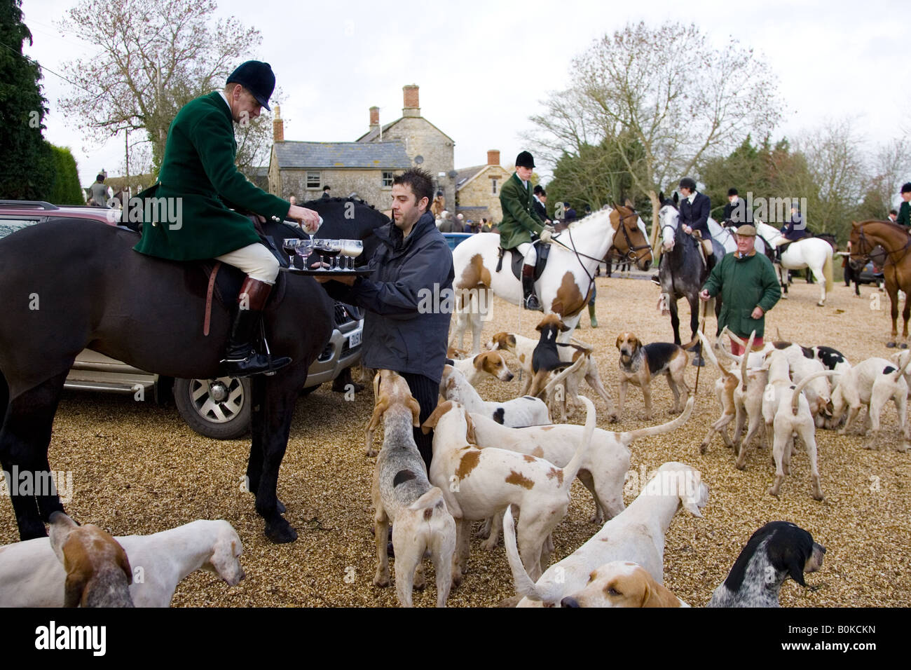 Members of Heythrop Hunt are offered traditional stirrup cup drinks at hunt meet The Cotswolds Oxfordshire Stock Photo