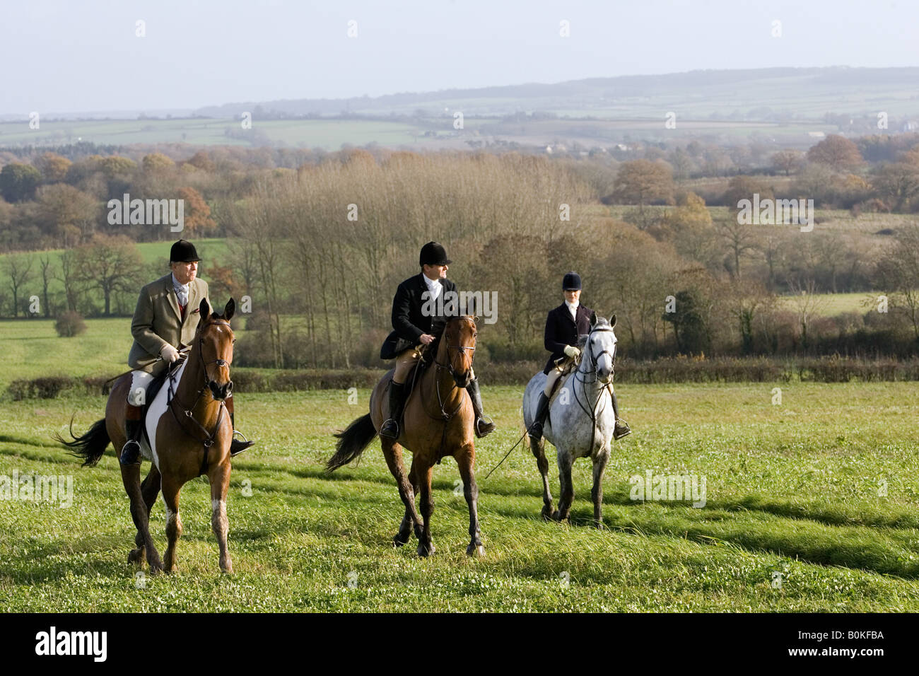 Members of Heythrop Hunt ride across field at Westcote The Cotswolds Oxfordshire United Kingdom Stock Photo