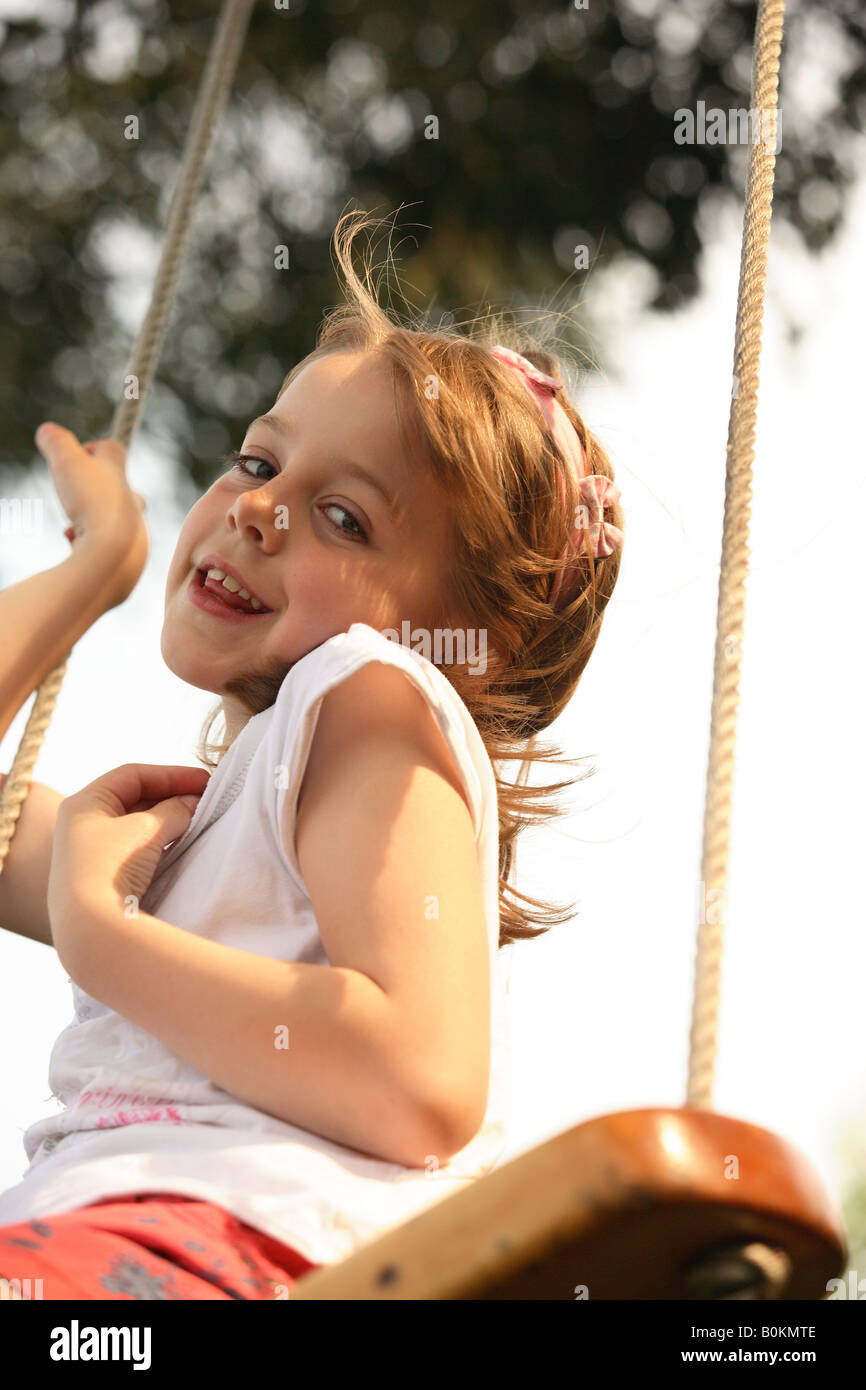 Carefree young girl on tree swing hi-res stock photography and images ...