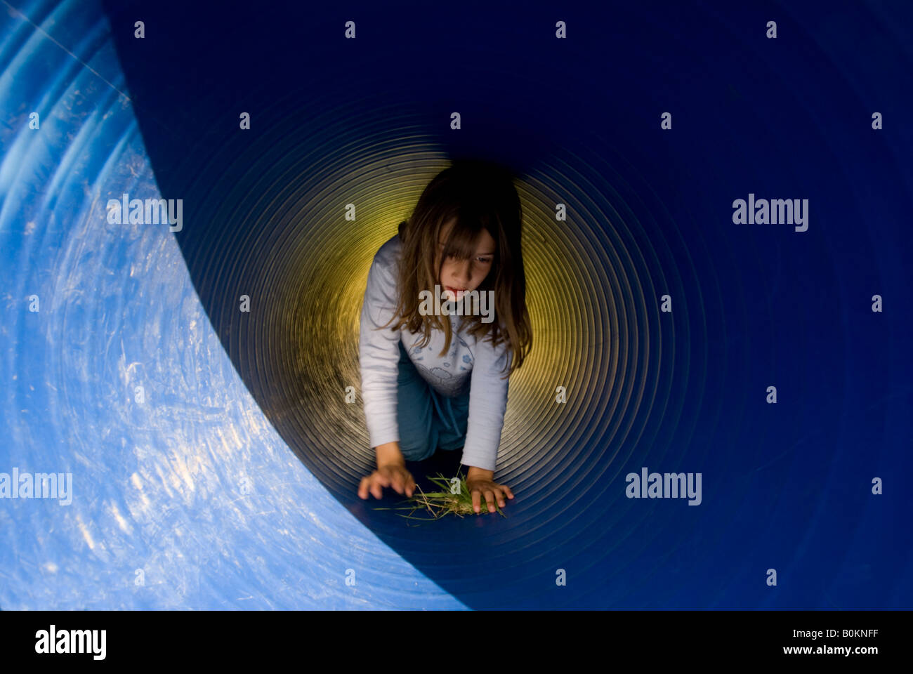 girl child crawling through blue pipe tunnel Stock Photo Alamy
