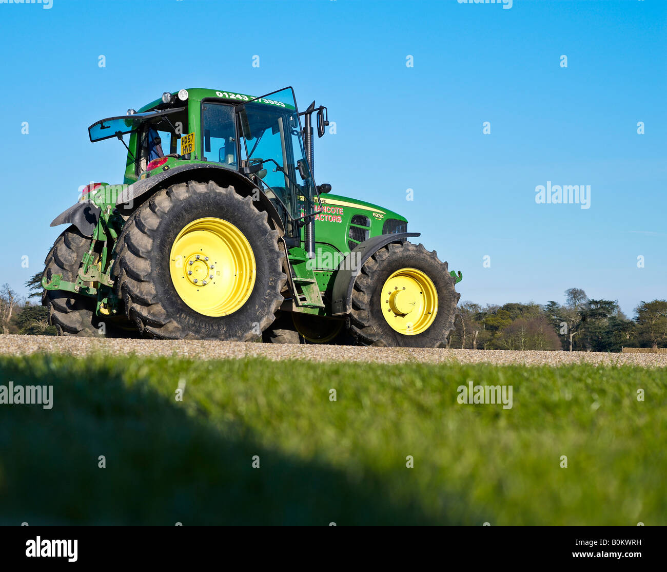 Green and yellow John Deere tractor under blue sky Stock Photo - Alamy