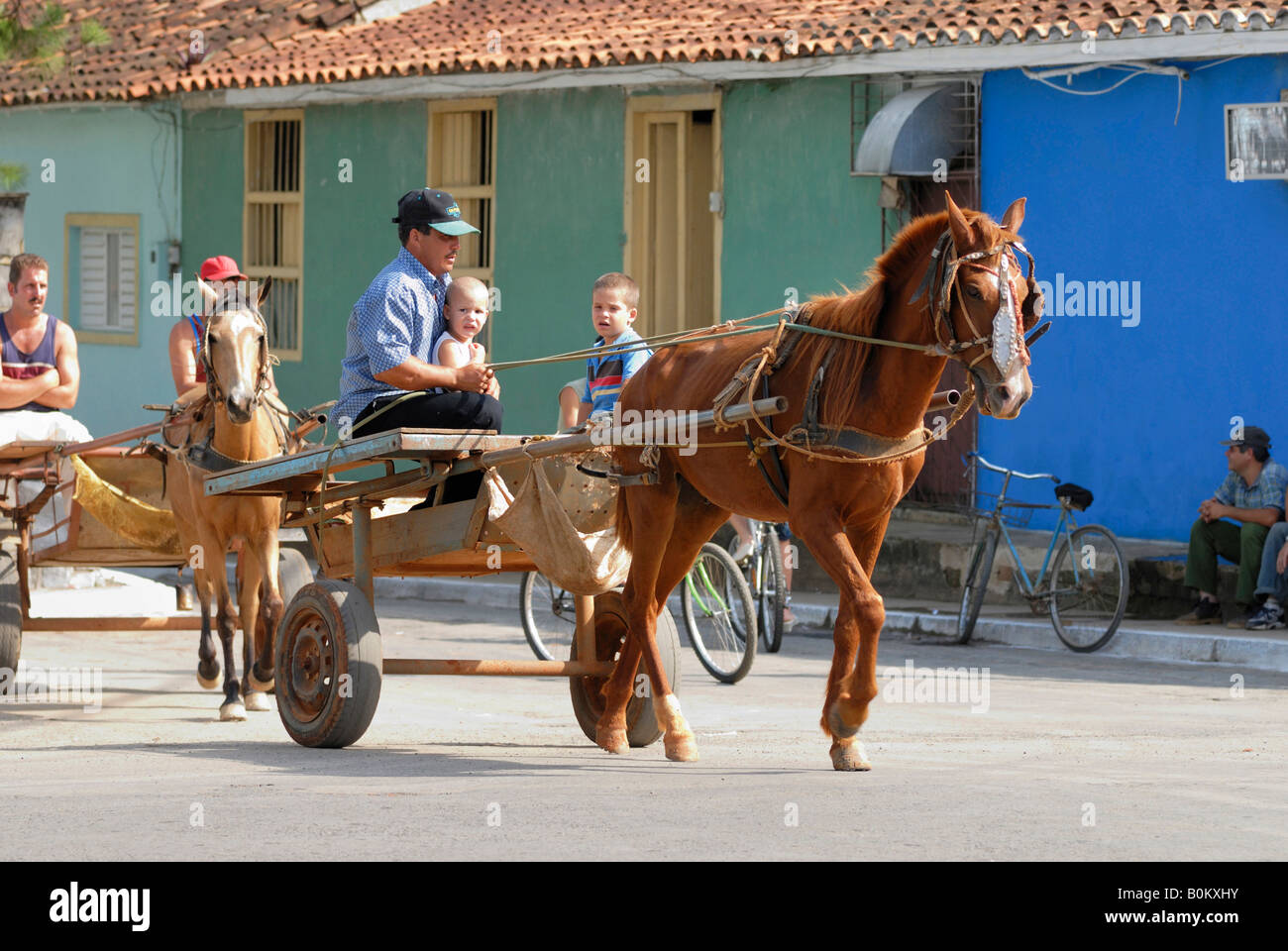 Two boys and three middle aged men driving by horse carriages in Vinales Cuba April 2007 Stock Photo