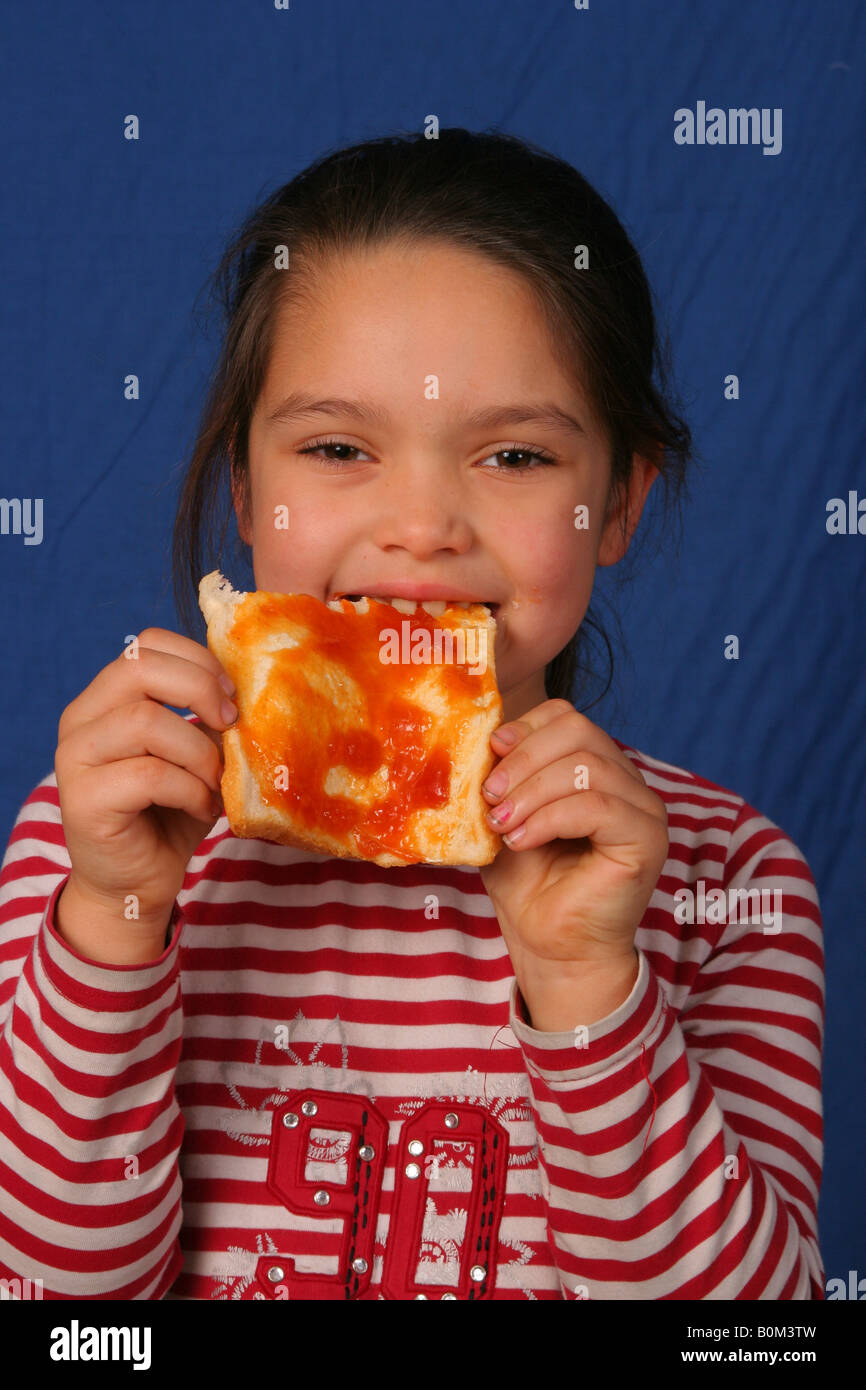 Young girl eating a jam sandwich Stock Photo Alamy