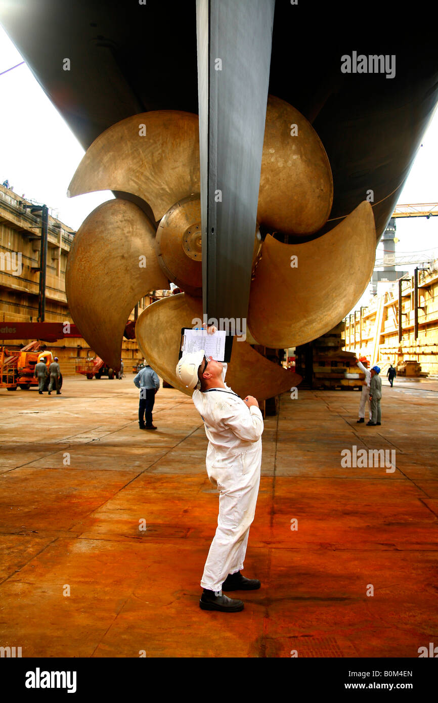 An engineer checks the rudder on a modern ship in dry dock Stock Photo