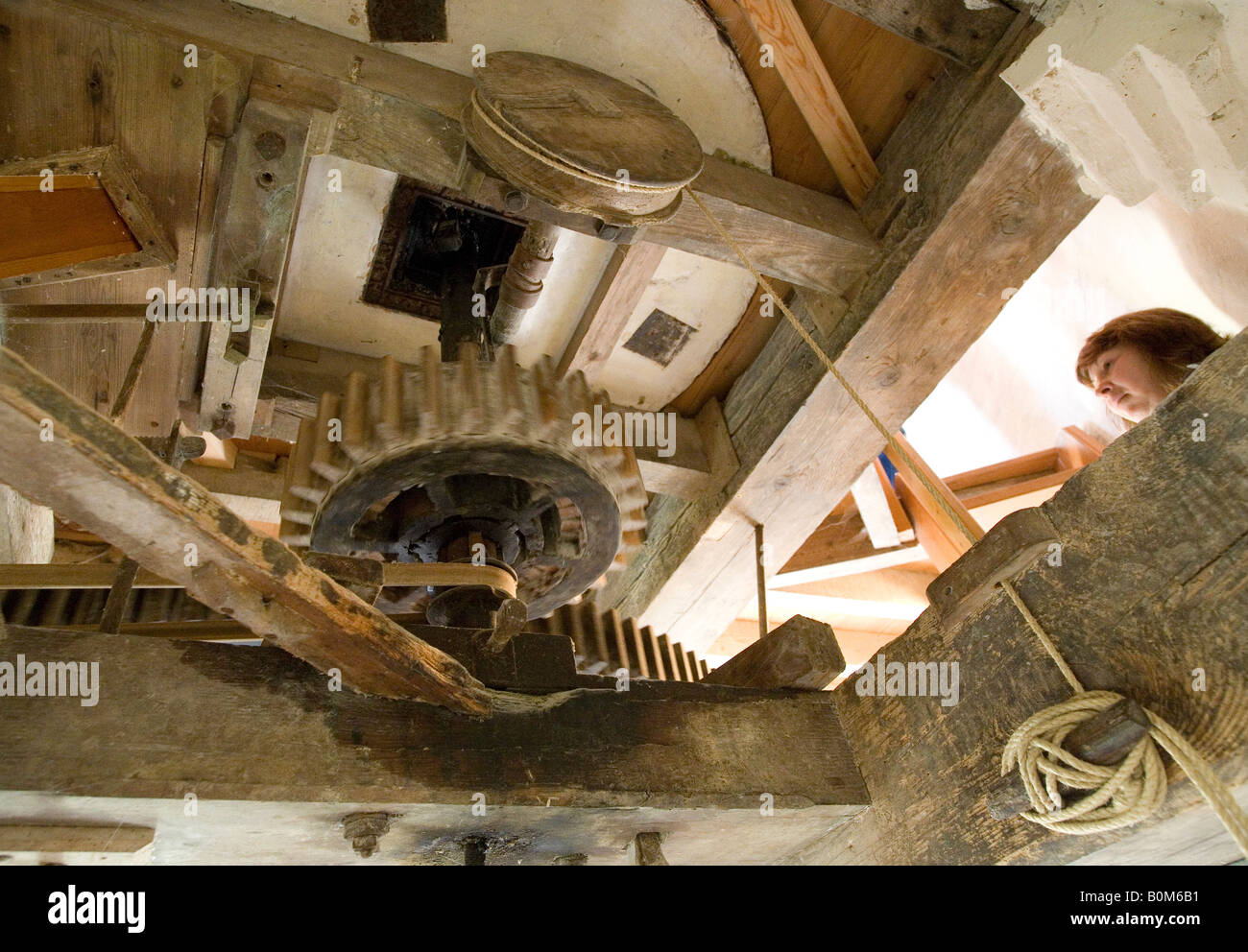 A tourist examines the internal workings of Fosters Windmill, Swaffham Prior, Cambridgeshire Stock Photo