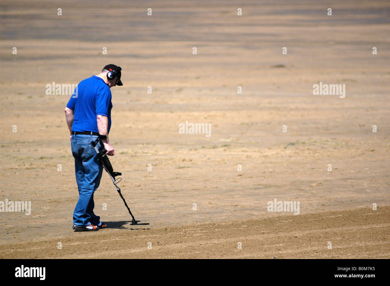 man using metal detector on beach Stock Photo - Alamy