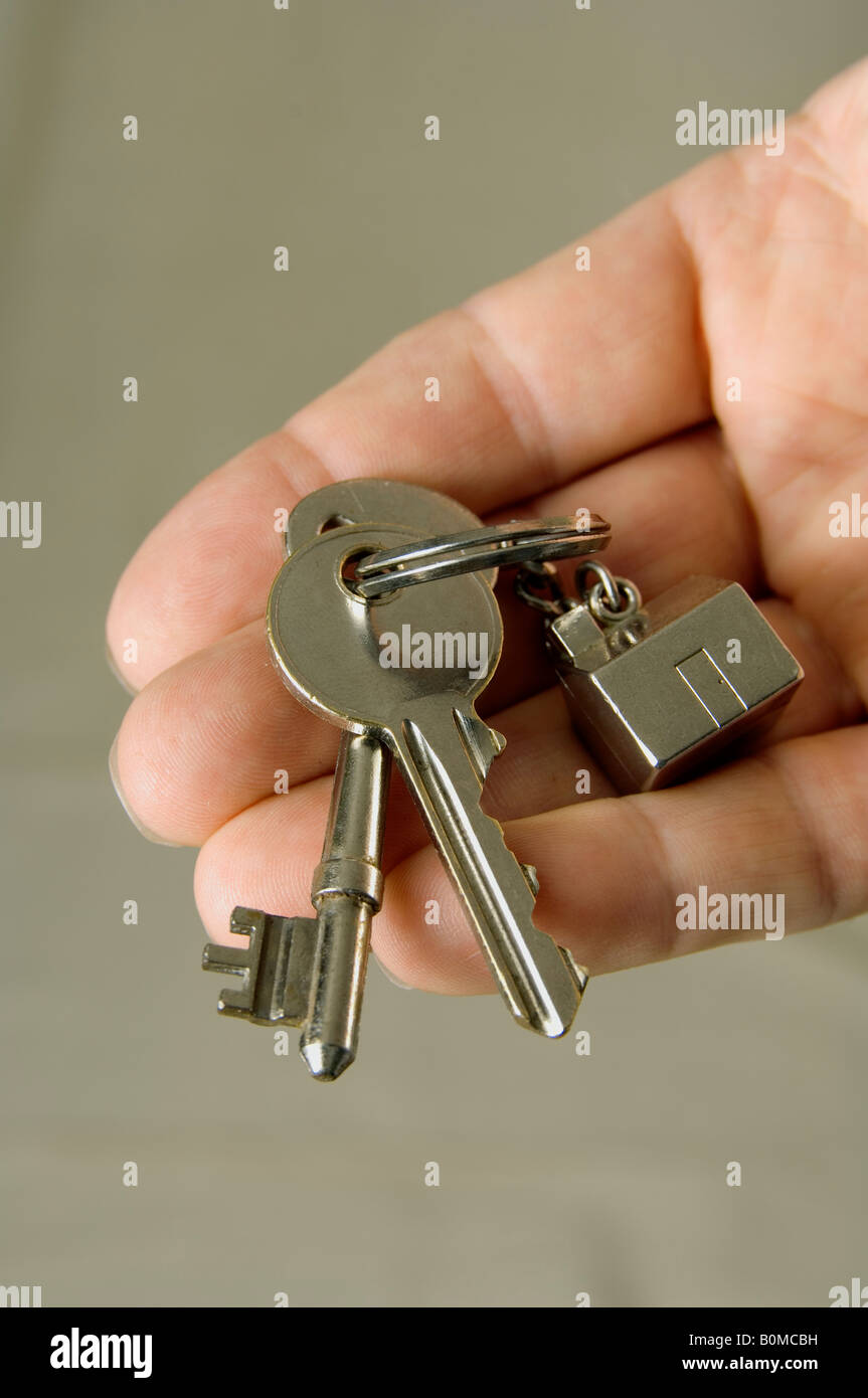 A man's hand holding house keys with a house fob Stock Photo