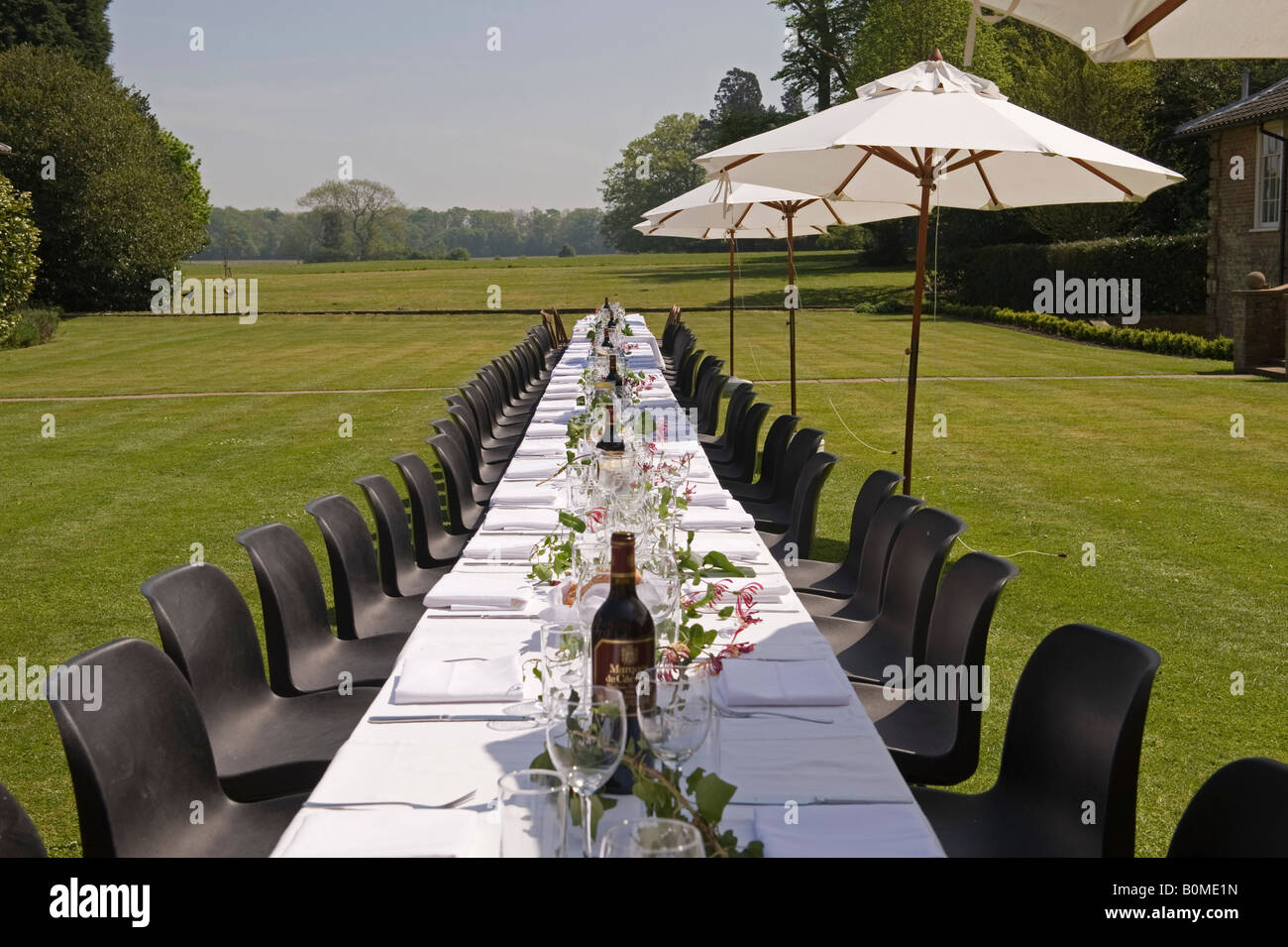 A long table laid for a family reunion and lunch party in the garden of an English country house Stock Photo