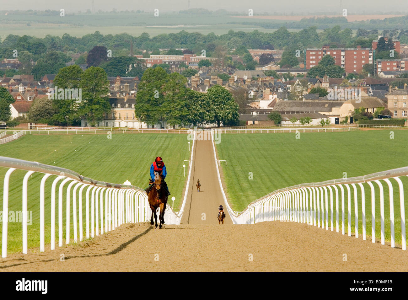 Racehorses and their jockeys ride up the heath, Newmarket Gallops, Newmarket, Suffolk, England Stock Photo