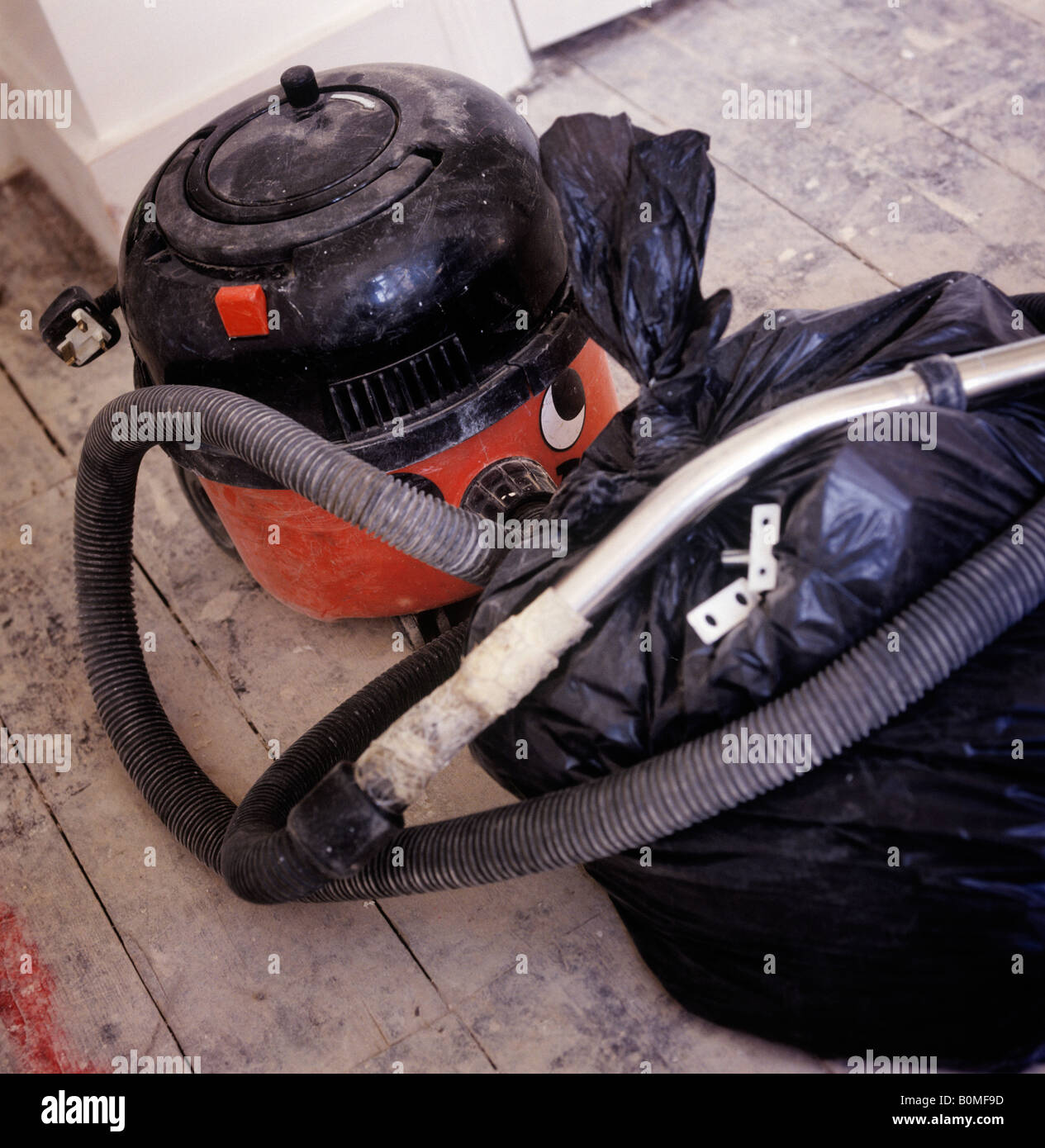 a builders henry hoover vacuum cleaner and black bin bag Stock Photo