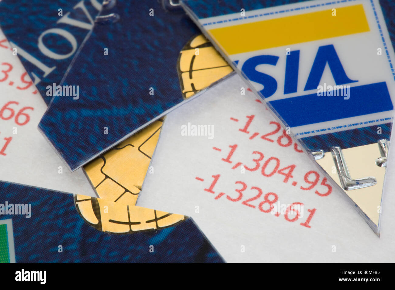 Cut Visa credit card in pieces on statement in red in close up Stock Photo