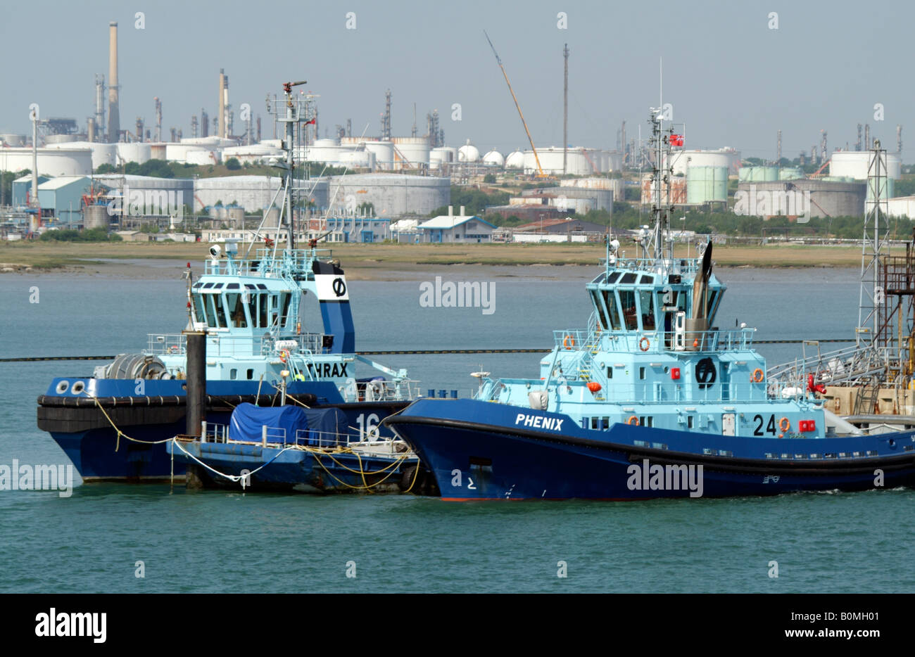 Fawley Marine Terminal and berthing tugs Thrax and Phenix on Southampton Water southern England UK Stock Photo