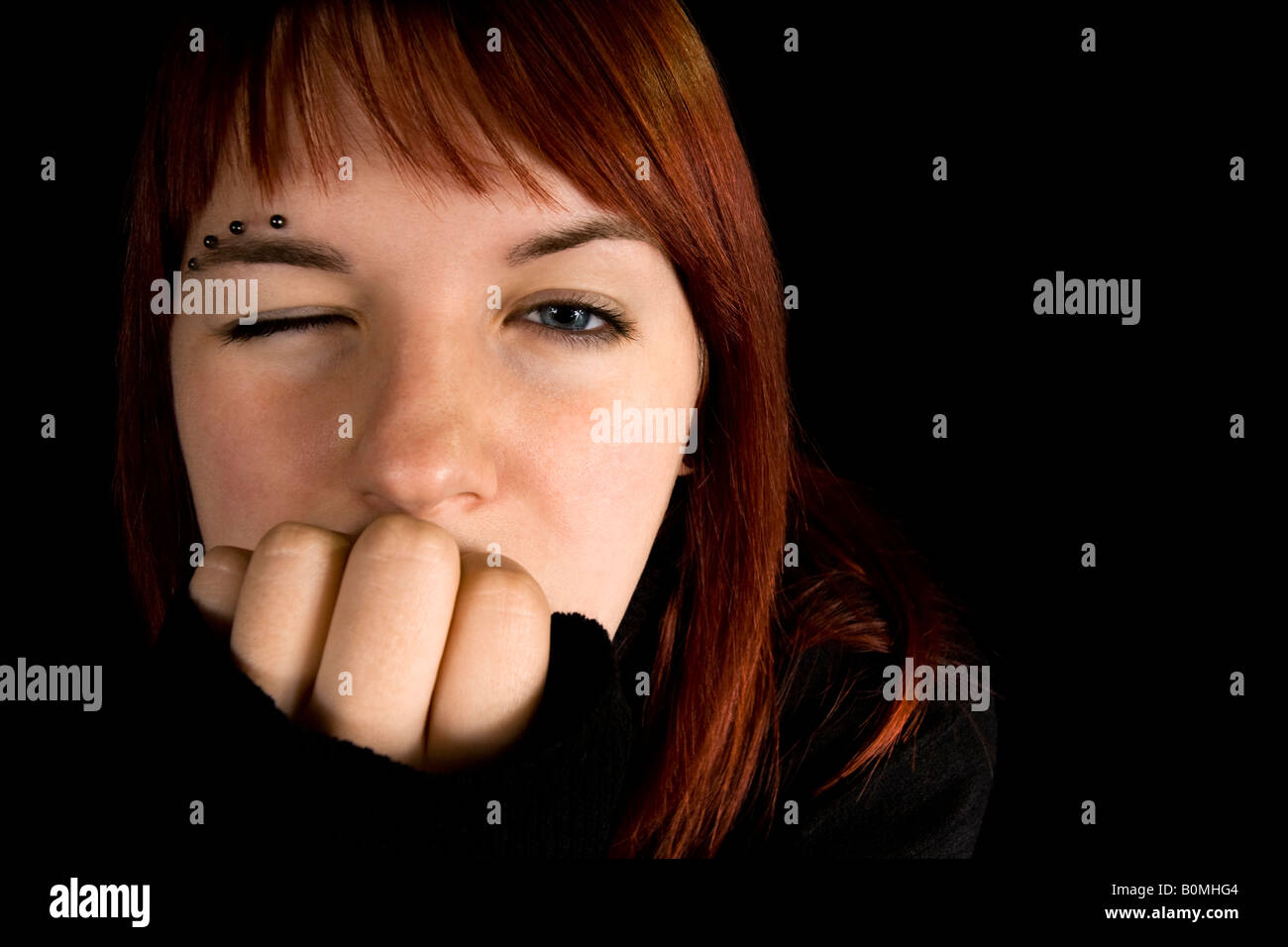 Redhead girl with one eye closed Lit with three flashes hair light