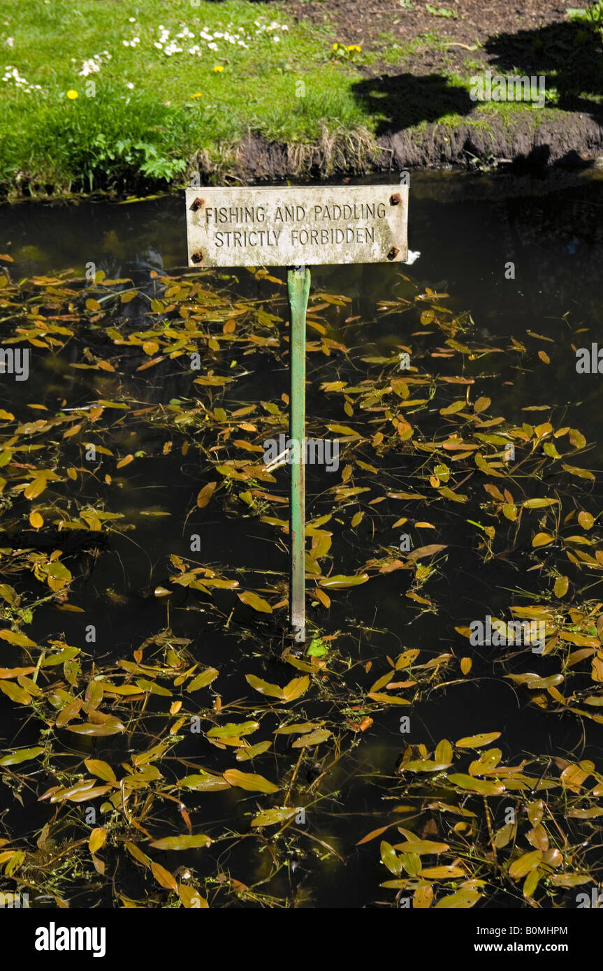A sign stuck in a pond at the National Botanic Gardens, Glasnevin, Dublin Ireland saying No fishing or paddling allowed Stock Photo
