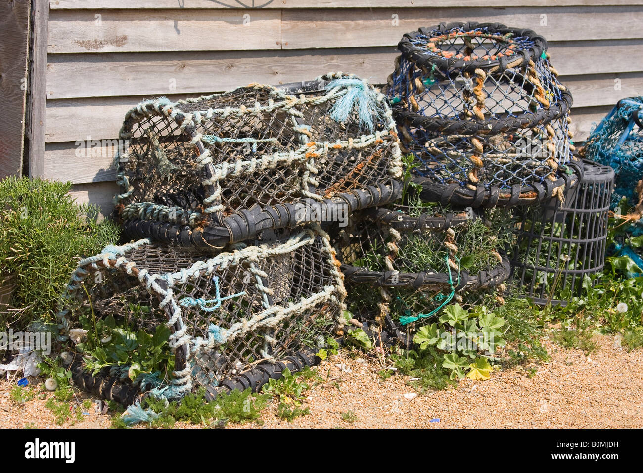 Lobster pots in front of boathouse wall on beach at Steephill cove, Isle of Wight, England, UK Stock Photo