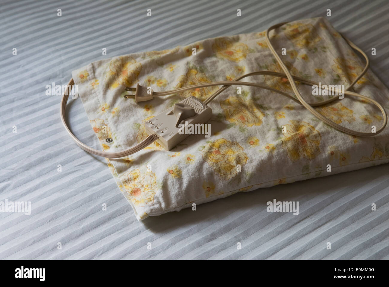 electric heating pad on bed sheet Stock Photo Alamy