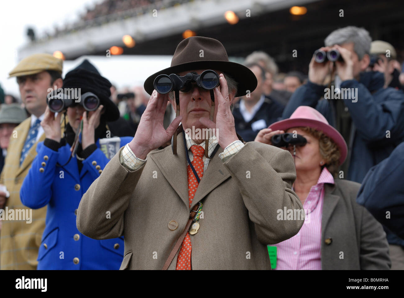 Racegoers with binoculars watch the horse racing at the Cheltenham National  Hunt Festival Stock Photo - Alamy