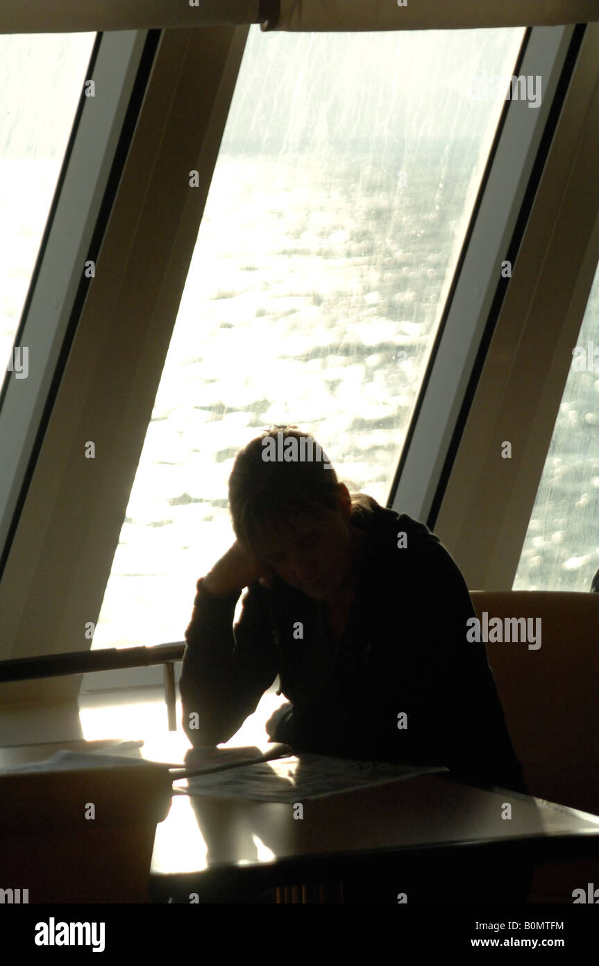 Person reading in restaurant Pont Aven ferry Brittany Ferries Plymouth to Roscoff crossing Atlantic Ocean Stock Photo