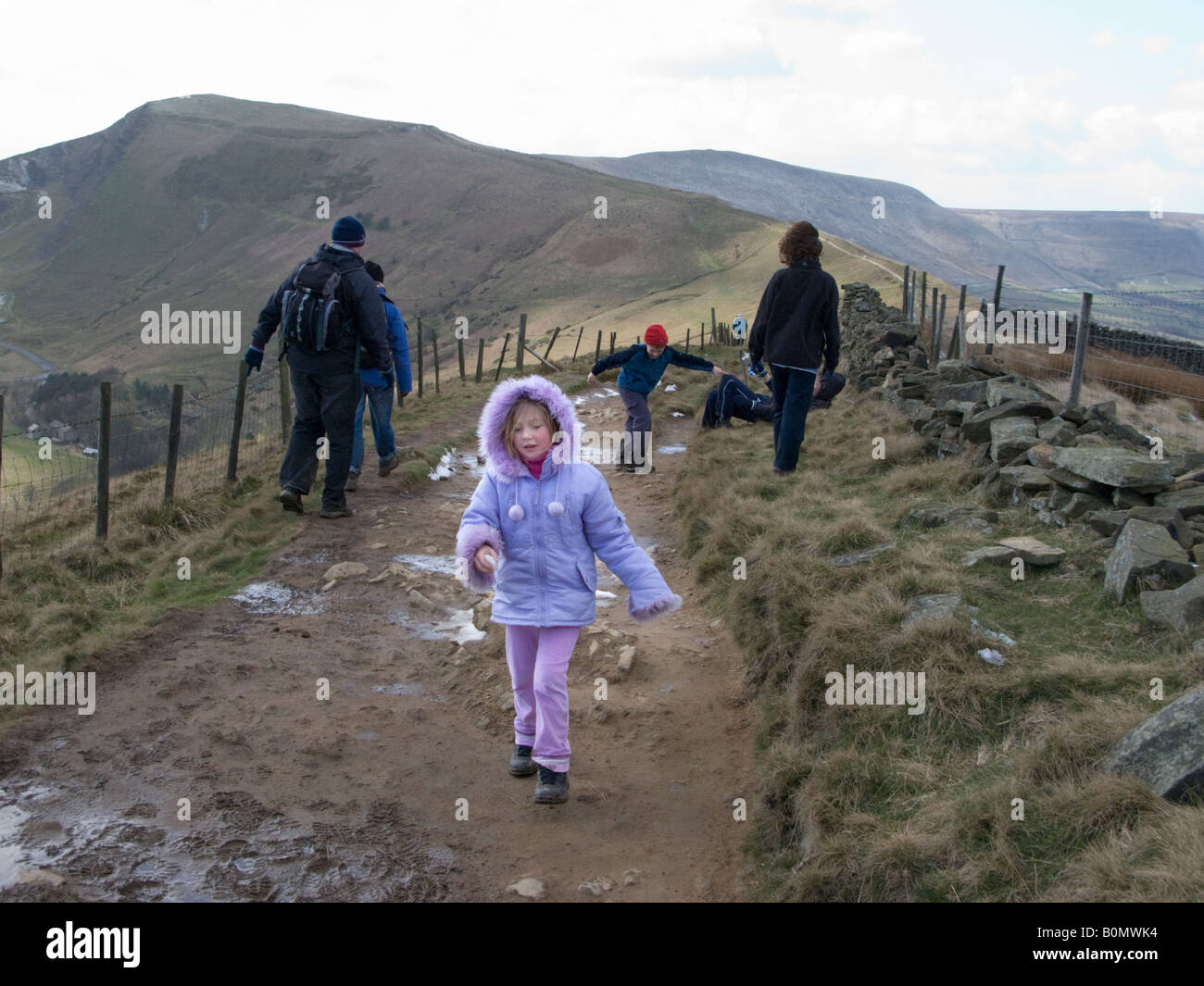 Young girl and her family walking the footpath over Mam Tor. Peak District National Park. UK Stock Photo