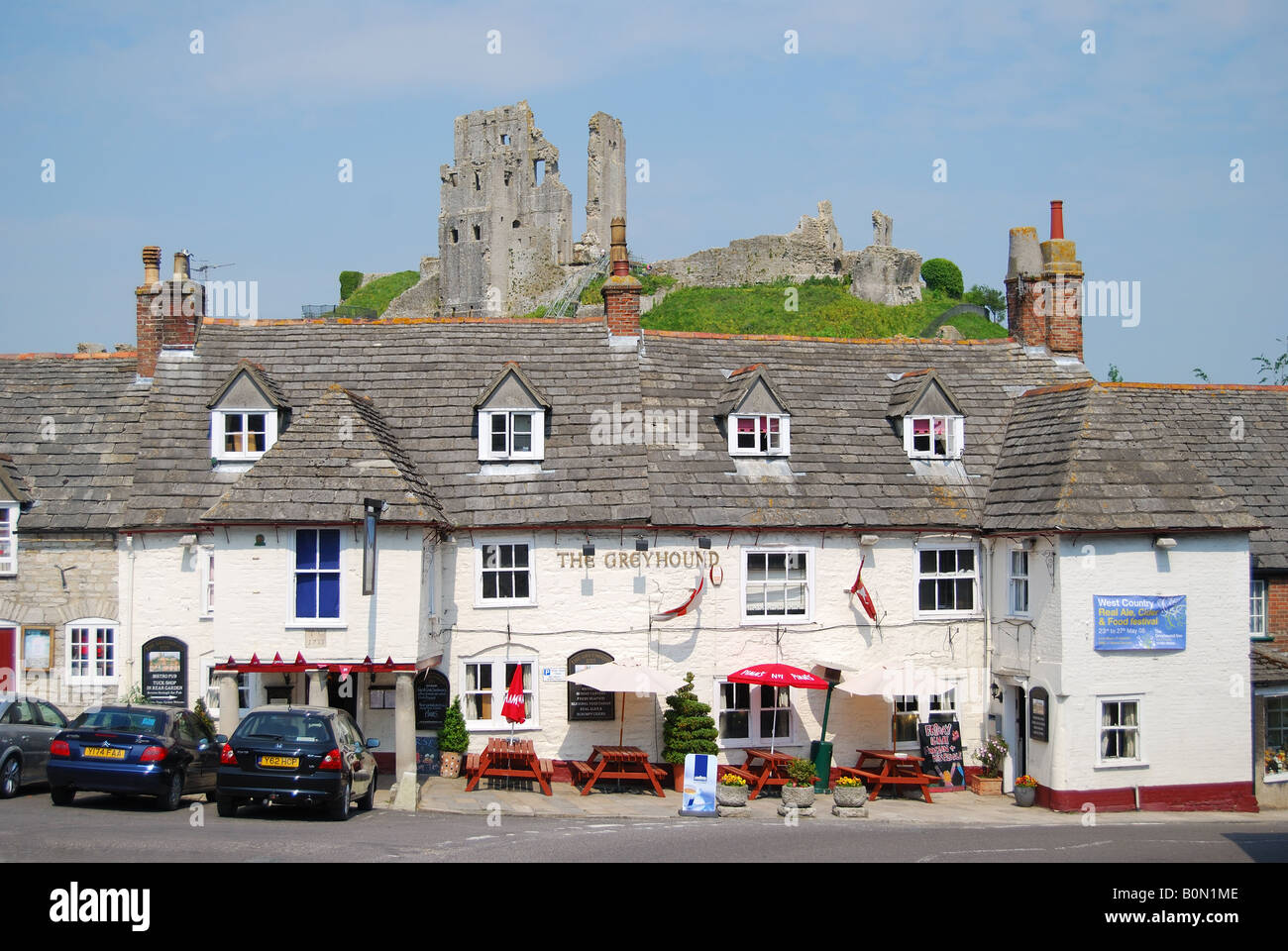 The Greyhound Inn with Castle ruins behind, The Square, Corfe Castle, Dorset, England, United Kingdom Stock Photo
