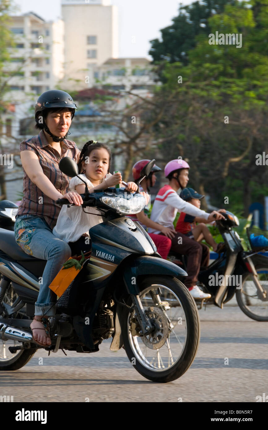 Woman and a girl on a scooter on Trang Tien, Hanoi, Vietnam Stock Photo ...