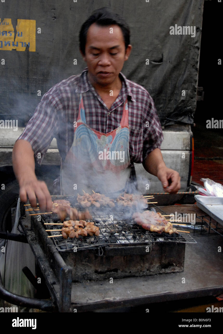 bbq chicken , street chef outside temple, chinatown, bangkok, thailand
