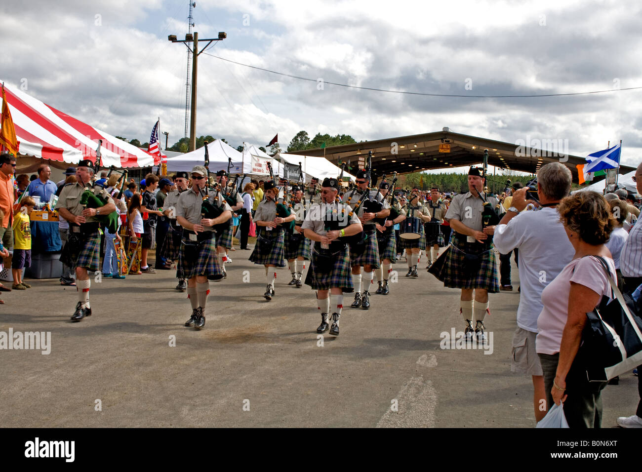 Parade of bagpipers marching on a road at the Clay County Fairgrounds during the Scottish Highland Games Stock Photo