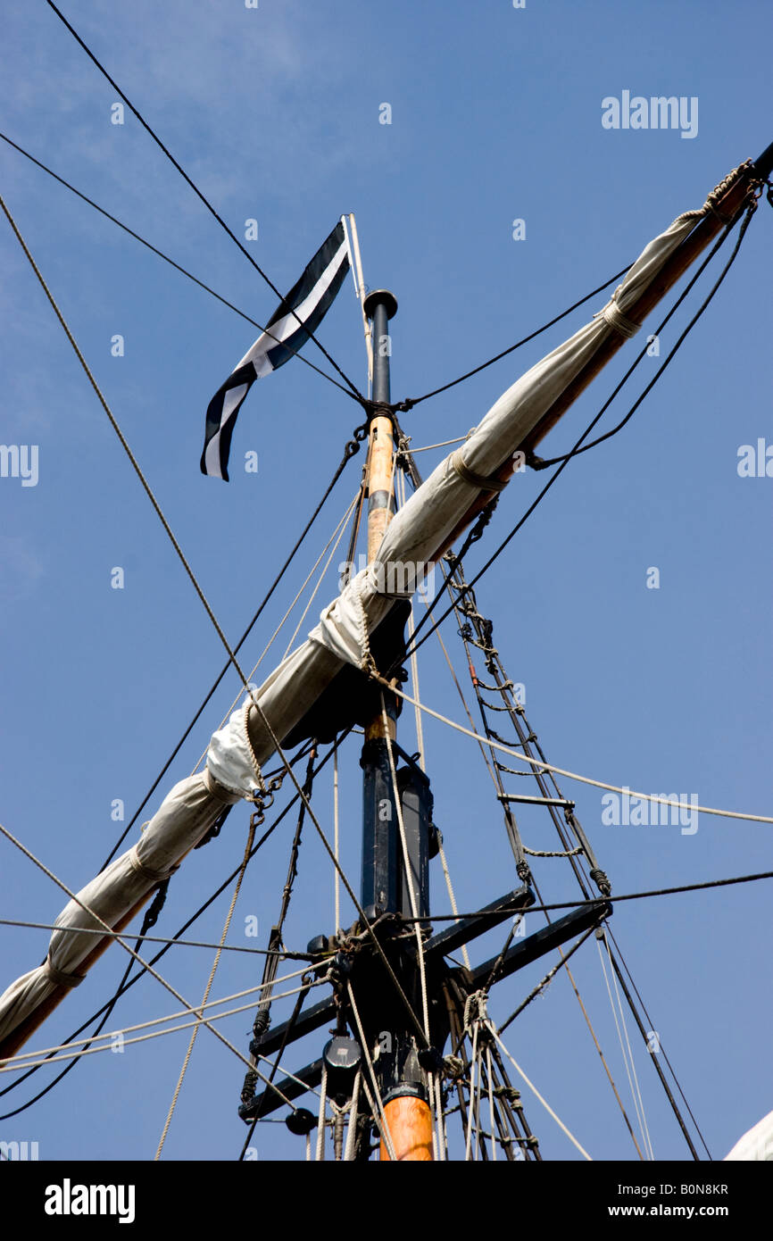 Mast of an old sailing ship flying the Cornish flag of St Piran Barbican Plymouth harbour England Stock Photo