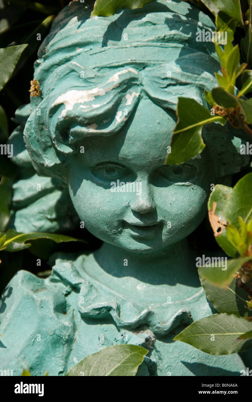 Stock photo of a garden statue of a little girl The statue is next to a