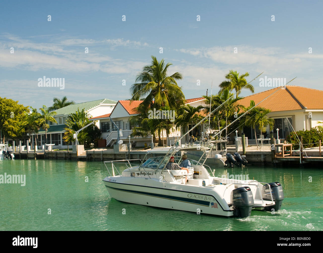 editorial leisure boat cruising canal in florida keys by houses Stock
