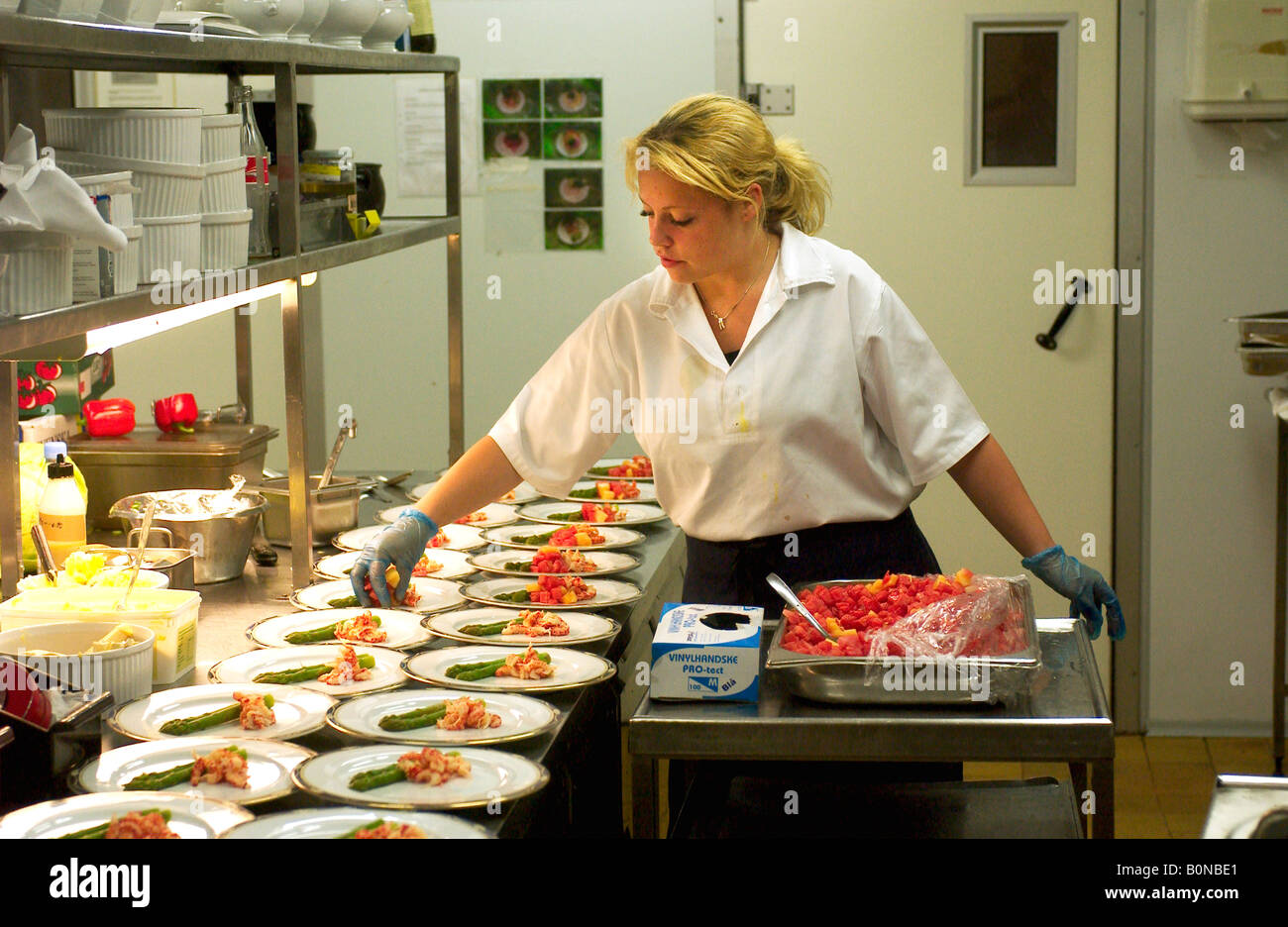 A cold-buffet manageress prepares a starter course in a restaurant kitchen Stock Photo