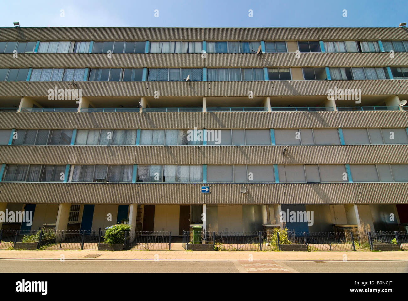 Horizontal view of the front facade of an empty block of houses on the Ferrier Estate in Kidbrooke Park on a bright sunny day Stock Photo