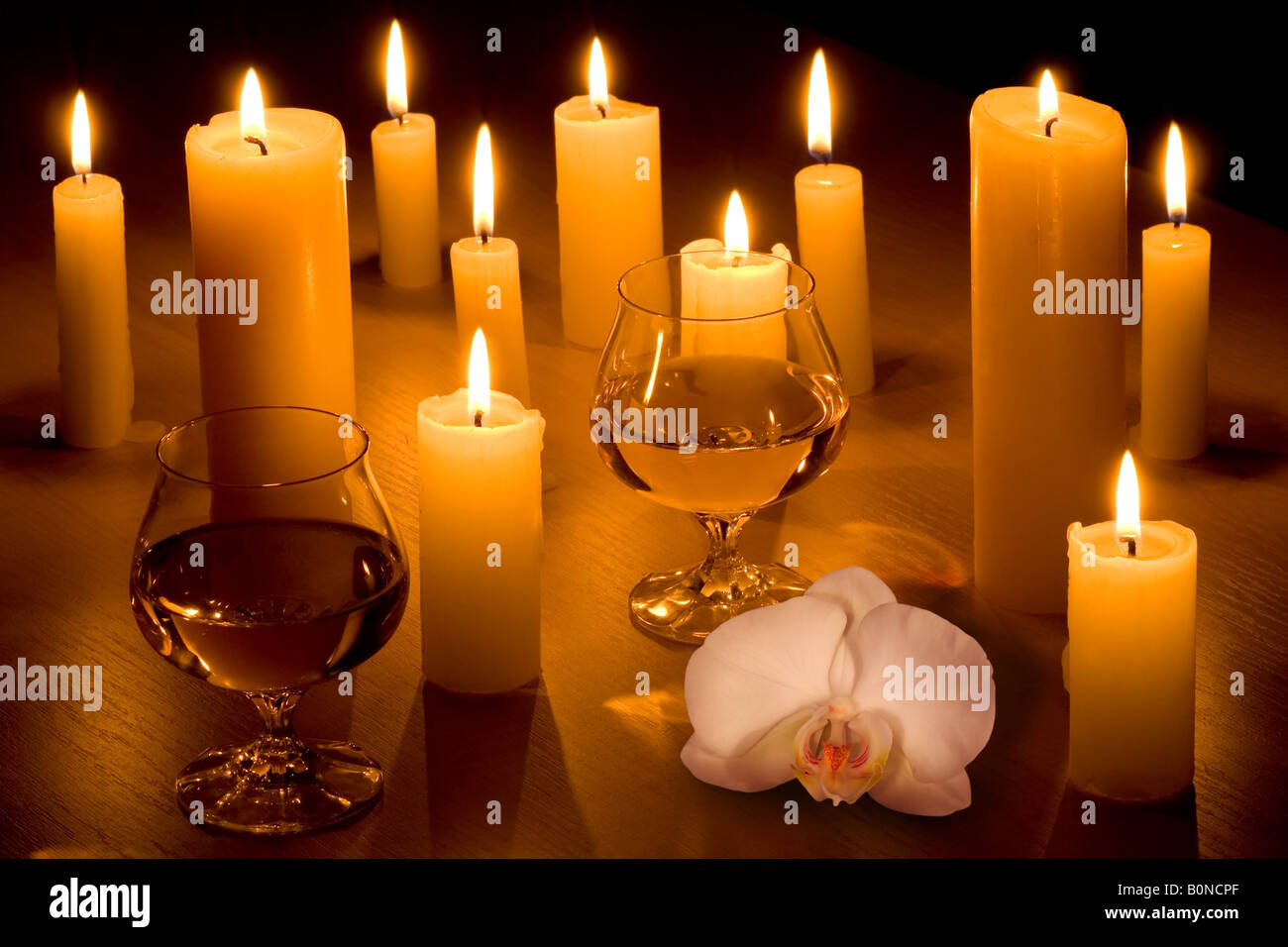 Romantic table with a lot of candles two glasses of wine and white orchid Stock Photo