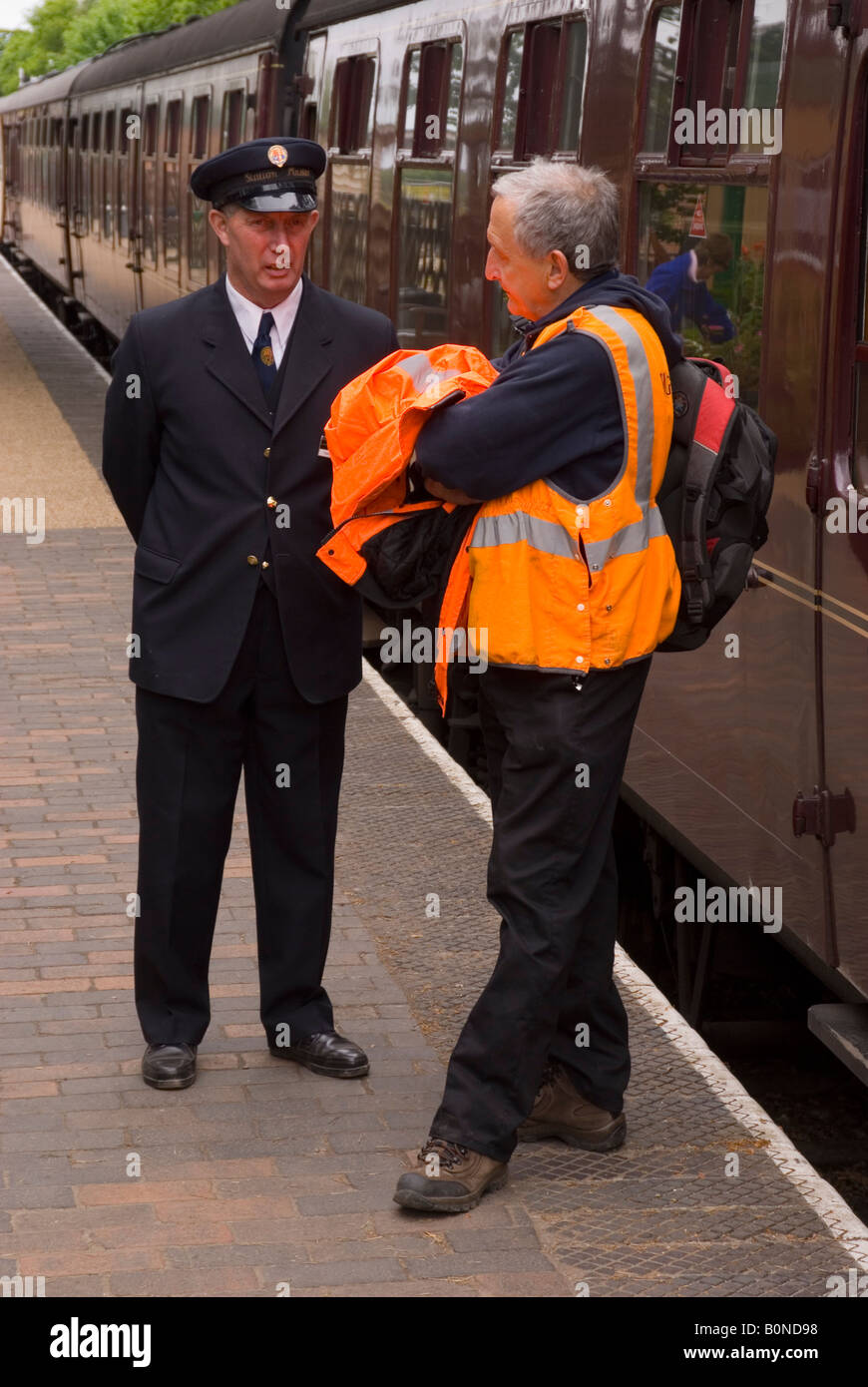 The Station Master Talking To Railway Worker At Holt Station,Norfolk,Uk Stock Photo