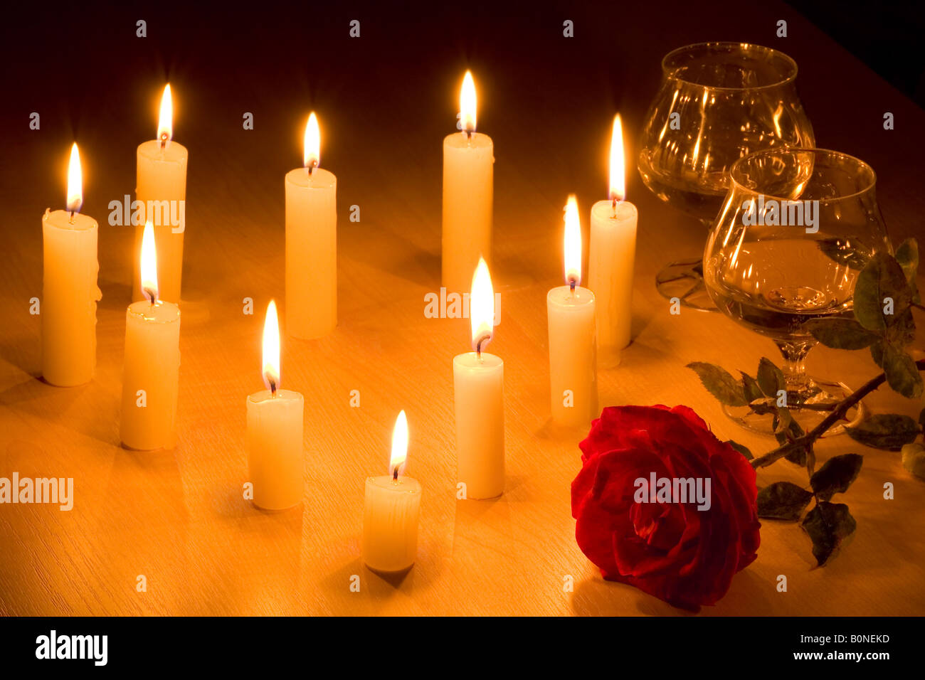 Romantic table with flaming heart of candles two glasses of wine and red rose Stock Photo